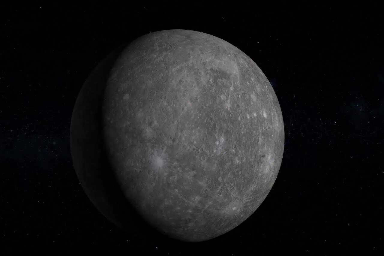 A detailed image of the planet Mercury in space, showing its gray, cratered surface with a dark starry background. The planet appears partially shadowed, highlighting its rocky texture and barren landscape.